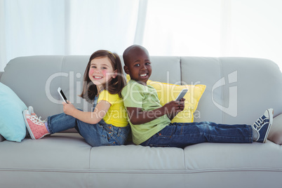 Smiling girl and boy using mobile phones