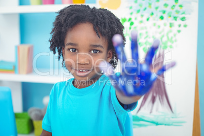 Happy kid enjoying painting with his hands
