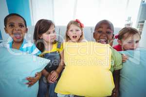 Happy kids holding couch cushions