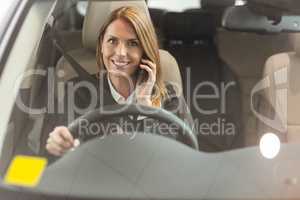 Smiling businesswoman having a phone call while sitting in a car