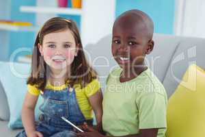 Smiling girl and boy using smartphone