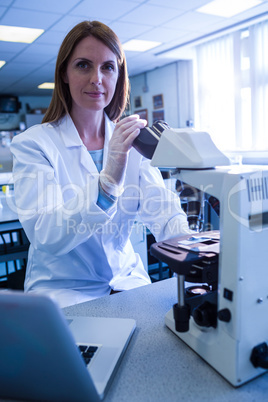 Scientist working with a microscope in laboratory