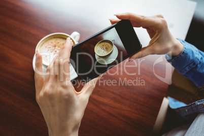 Woman taking a photo of her coffee