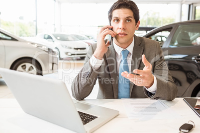 Smiling salesman having a phone call