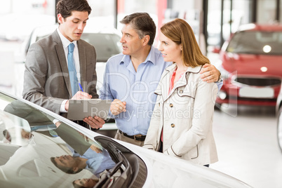 Smiling businessman presenting a car