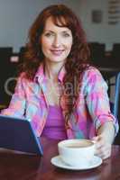 Mature student using tablet in cafe