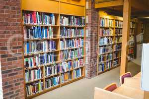 Student reading a book from shelf in library