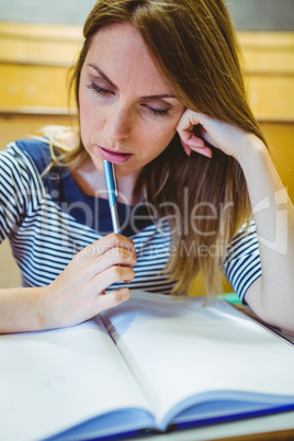 Mature student taking notes in lecture hall