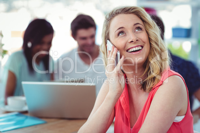 Smiling creative businesswoman working with co-workers