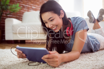 Asian woman using tablet on floor