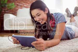 Asian woman using tablet on floor