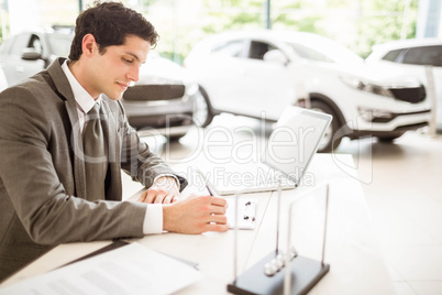 Smiling salesman at his desk