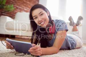 Asian woman using tablet on floor