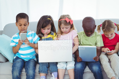 Happy kids using technology while sitting