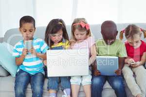 Happy kids using technology while sitting