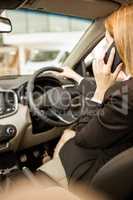 Businesswoman having a phone call while siting in a car