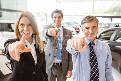 Group of smiling business team pointing together