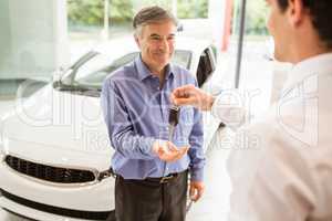 Businessman giving car key to a customer