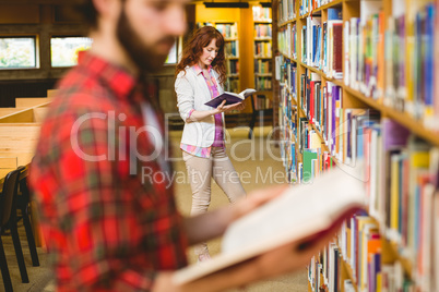 Hipster student picking a book in library