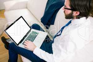 Businessman using laptop on the couch