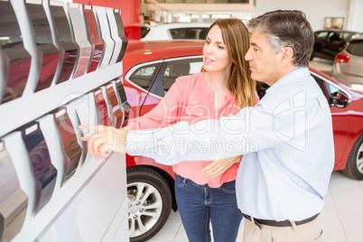 Smiling couple choosing the color of their new car