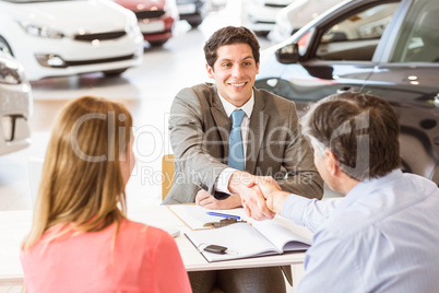 Smiling couple buying a new car