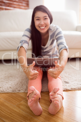 Asian woman using laptop on floor