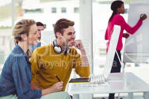 Graphic designer wearing headphones at desk