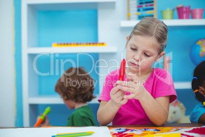 Small girl holding a red crayon