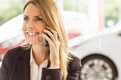 Smiling saleswoman having a phone call