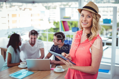 Smiling creative businesswoman working with co-workers