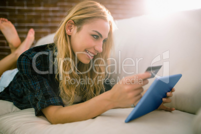 Pretty blonde relaxing on the couch using tablet