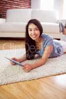 Asian woman using tablet on floor