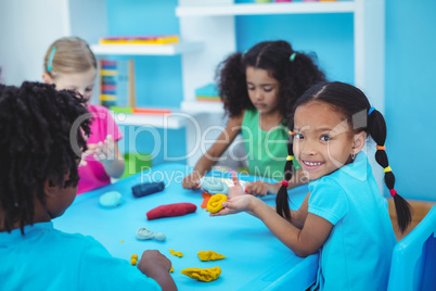 Smiling kids using modelling clay