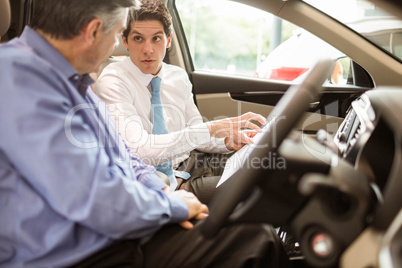 Businessman pointing a car interior