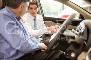 Businessman pointing a car interior