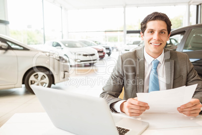 Smiling salesman reading a document