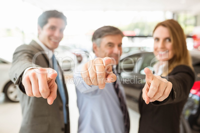 Group of smiling business team pointing together