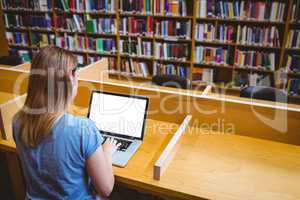 Mature student in the library using laptop