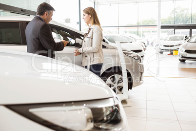 Salesman showing a car to a client