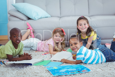 Smiling kids drawing pictures on paper