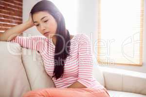 Upset asian woman on couch
