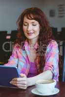 Mature student using tablet in cafe