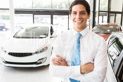 Smiling businessman standing with arms crossed