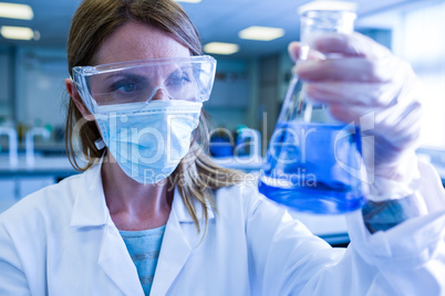 Scientist holding up beaker of chemical