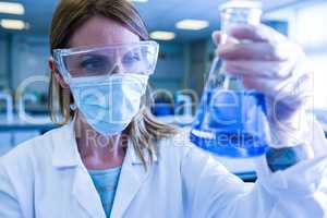 Scientist holding up beaker of chemical