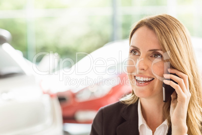 Smiling saleswoman having a phone call