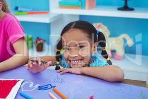 Children drawing on coloured paper