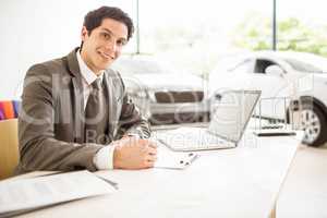 Smiling salesman behind his desk