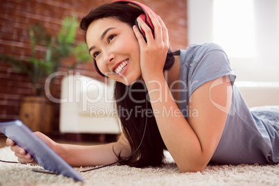 Asian woman using tablet on floor